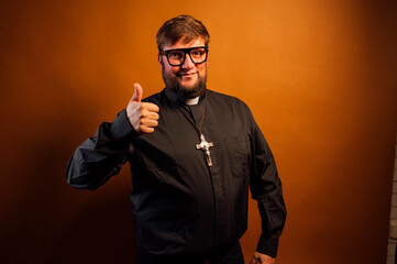 Portrait of a priest with crucifix making hand gestures.