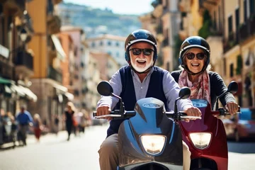 Fototapeten An elderly cheerful emotional couple in oscars rides a scooter along a city street © Александр Лобач
