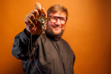 Portrait of an exorcist priest with crucifix and black shirt.