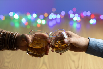 Close-up of two men clinking whiskey glasses. drink alcohol