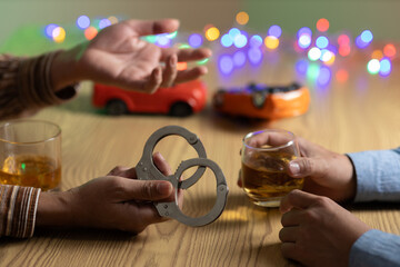 Two men clink whiskey glasses while in front of a bar in a restaurant. With a small car model on...