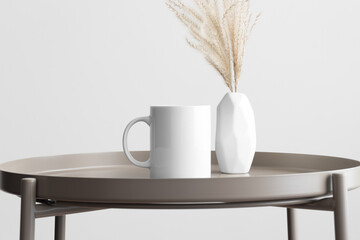 White mug mockup with a reed pampas decoration on the beige table.