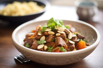 Fototapeta premium lamb tagine with almonds and figs topping in pot