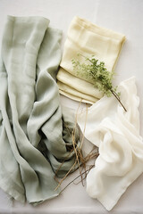 Green and white silk shawl on a white tablecloth.