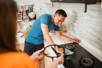 asian man install grill stove after maintenance in the kitchen