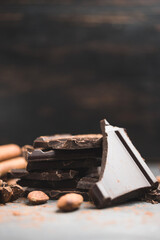 Heap of delicious dark chocolate pieces or cubes, chopped, broken chocolate bar, almond nut,...