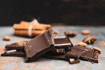 Heap of delicious dark chocolate pieces or cubes, chopped, broken chocolate bar, almond nut,...