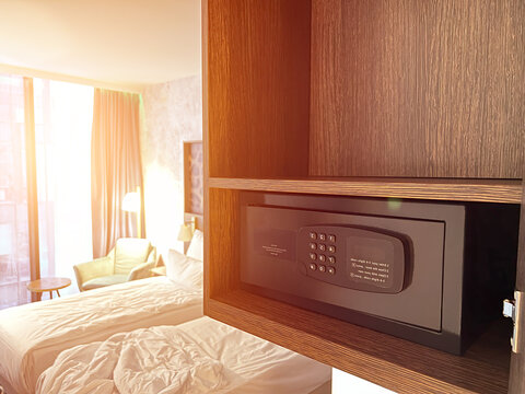 Money and documents in an open digital safe on a closet shelf. The safe has a keypad and a screen for security and protection. The safe can be locked and unlocked with a code and a password.