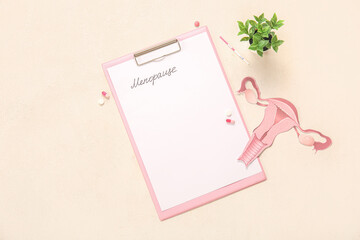 Clipboard with word MENOPAUSE, pills, paper uterus and pregnancy test on light background