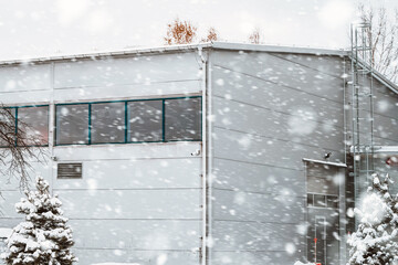 The modern warehouse complex in winter. Large industrial manufacturing and logistics building in winter and snow weather.