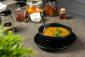 Indian soup Dahl in a plate on a background of spices