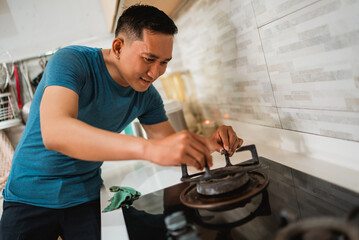 asian man install grill stove after maintenance in the kitchen