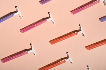 Many colorful safety razors on pink background