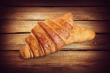 Tasty fresh golden croissant on desk