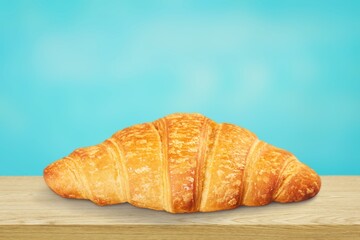 Tasty fresh golden croissant on desk