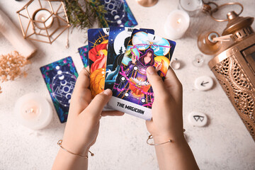 Witch with tarot cards on grunge table, closeup