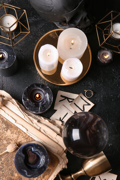 Witch's magic attributes with burning candles on dark background
