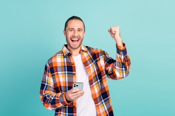 Portrait of overjoyed crazy guy with stubble wear flannel shirt hold smartphone shout win lottery...