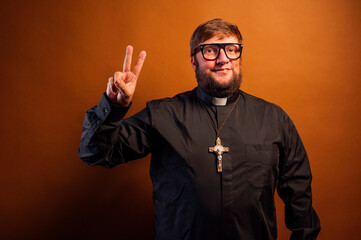 Portrait of a priest with crucifix making hand gestures.