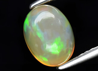 natural multi color rainbow opal gem on the background