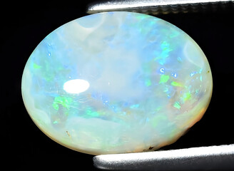 natural multi color rainbow opal gem on the background