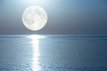 Full moon with a lunar path reflected in the mirror of the sea.