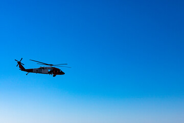 Military American helicopter flies in the blue sky. Military, rescue equipment.
