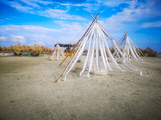 Beautiful straw umbrellas and sunbeds on beach near sea