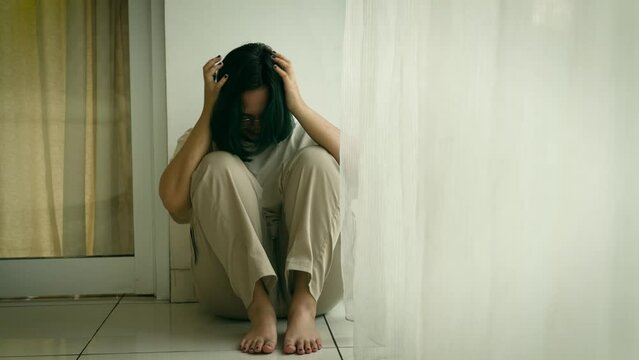 Young unhappy woman teenager girl with long hair in jeans sitting on floor