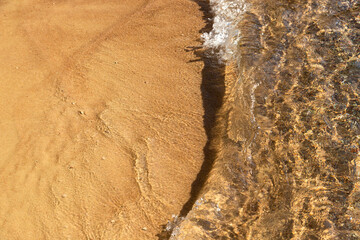 Breaking wave on the sandy seashore, View from the top. Background.