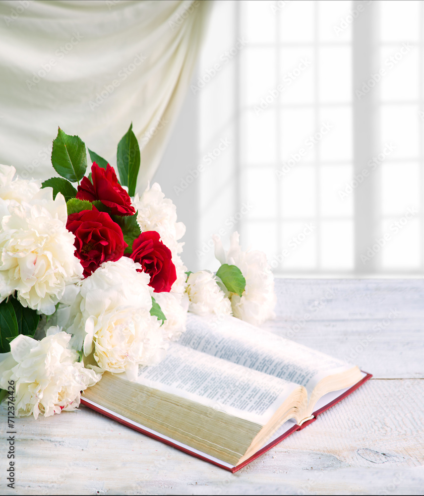 Wall mural Bible and a bouquet of peonies on a table