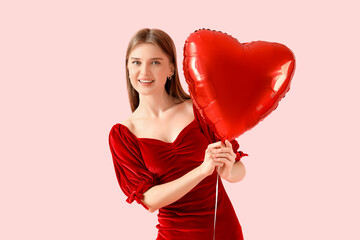 Beautiful woman with heart-shaped balloon on pink background. Valentine's Day celebration