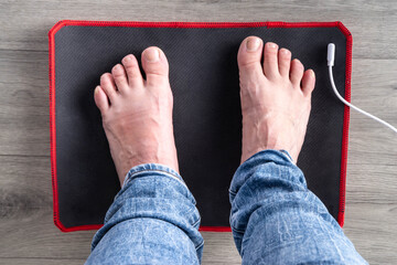 Grounding Mat concept. Home Using wellbeing, wellness electric charge mat with woman foots it pic