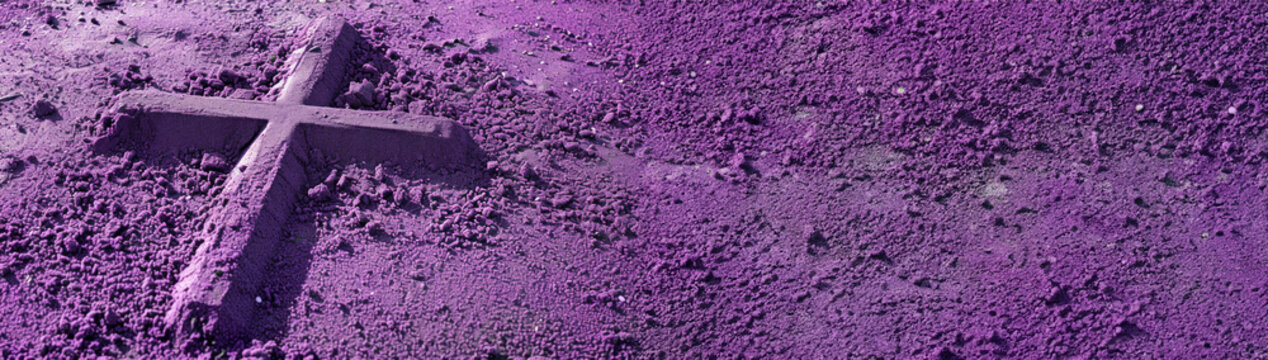 Ash Wednesday wide banner with imprint of cross drawn in purple ash. symbolic imprint of a cross in vibrant purple sand, depicting Ash Wednesday reflection and penance.