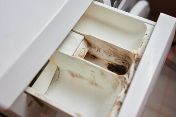 Dirt inside washing machine tray at the laundry detergent tray with a lot of moldy and dirty stain...