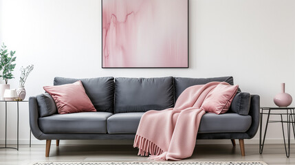  Grey sofa with pink pillows and blanket against white wall with abstract art poster. Interior design of modern living room