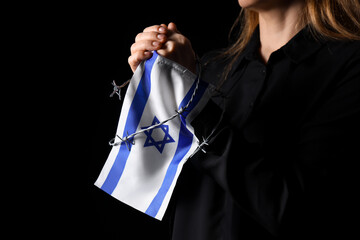 Naklejka premium Mature woman with flag of Israel and barbed wire on black background, closeup. International Holocaust Remembrance Day
