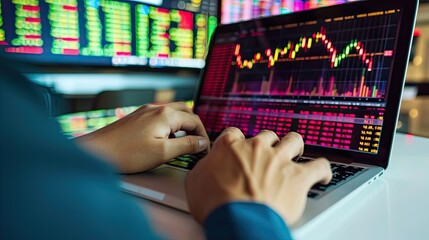 Trader investor analyst looking at computer screen analyzing financial graph data on monitor. Trader looking at market chart on laptop.