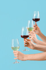 Women with glasses of wine on blue background. Valentine's Day celebration