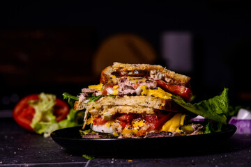 Tuna and vegetable sandwich on a black background