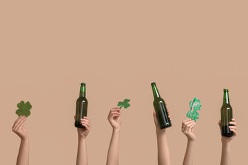 Many hands with beer, clover and party glasses on beige background. St. Patrick's Day celebration