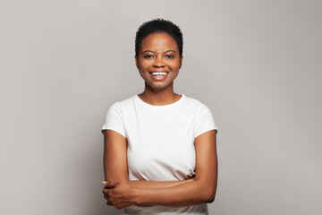 Confident happy woman smiling and having fun against white studio wall background, emotional...