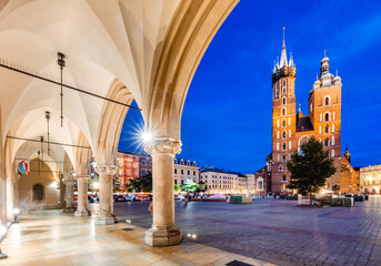 Cracow, Poland old town and St. Mary's Basilica seen from Cloth hall arch at night