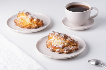 Russian baking with cottage cheese. Sochniki with cottage cheese on the plate and a cup of coffee