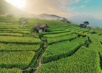 Landscape of rice terrace and hut with mountain range background and beautiful sunrise sky. Nature...