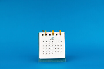 July 2024 mini desk calendar on blue background.