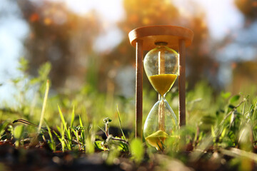 Hourglass in nature. Idea of ecology, time and preserving the earth - obrazy, fototapety, plakaty