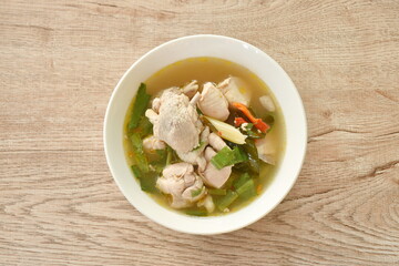 spicy boiled chicken and bone with herb leaf tom yum soup on bowl