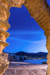 The picturesque seaside village of Cefalù seen from a stone arch, Sicily - 712402448