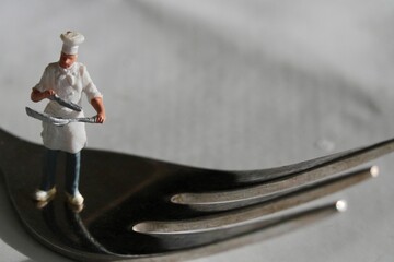 miniature figurine of a chef with a fork preparing some food